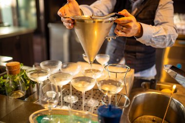 Laverstoke Mill, Whitchurch, Hampshire, İngiltere. 25.02.25 Bombay Safir içki imalathanesi, cin şoklama deneyimi. Barmen barın arkasında kokteyl hazırlıyor. seçici odak.