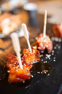 Susam tohumlu çubuklardaki jöleli domuz ısırıklarının yakın plan çekimi ısırıklara odaklanmak. Gurme yemek kavramı.