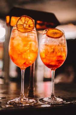 Zarif bir barda servis edilen portakal garnitürlü soğuk aperol spreyli kokteyller. 