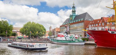 Panorama of a cruiseboat in front of the historic town hall of Emden, Germany clipart