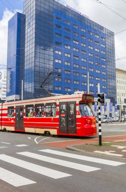 Red tram crossing the Spui square in Den Haag, Netherlands clipart