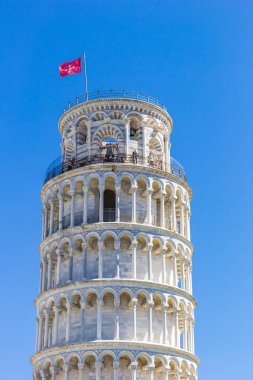 Traditional Pisan Cross flag on top of the leaning tower in Pisa, Italy clipart