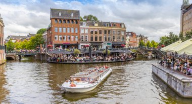 Tourists taking a canal tour in the historic center of Leiden, Netherlands clipart