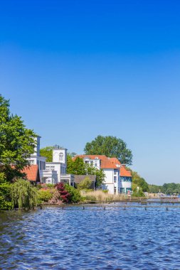 White houses at the waterfront of the lake in Bad Zwischenahn, Germany clipart