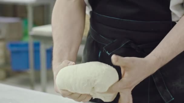 男人在厨房的特写镜头里把面团揉碎在桌上 工作中的专业面包师 — 图库视频影像