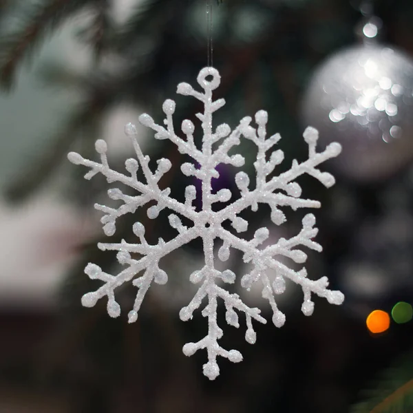 挂在有火花和玩具的冷杉树枝上的新年装饰雪花 — 图库照片