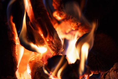 Şömine ve arka plandaki odun yanıklarından yüksek sıcaklıkta güzel parlak bir ateş.