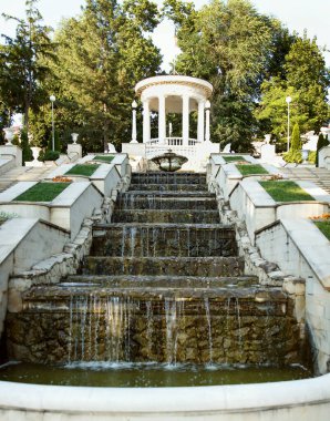 Restored rotunda and cascade ladder filled with water in the park pleases visitors. Fine modern architectural construction