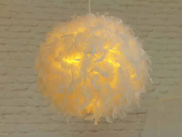 stock image Modern lamp with abajur made of white feathers, gives romantic light in bedroom