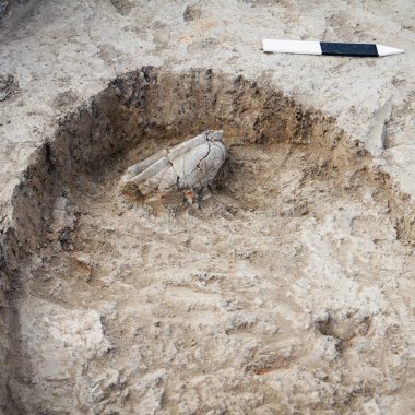 Arkeolojik kazılar, arkeologlar antik bir kil eserini kazıyorlar. Cetveller, bulunan iş ve ögelerin büyüklüğünü, derinliğini ve ölçeğini gösterir, kare