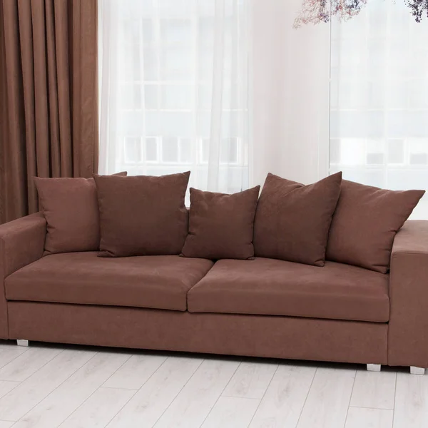 リビングルーム 正方形のモダンなインテリア家具の一部を形成し 5つの枕と美しい茶色のソファ — ストック写真