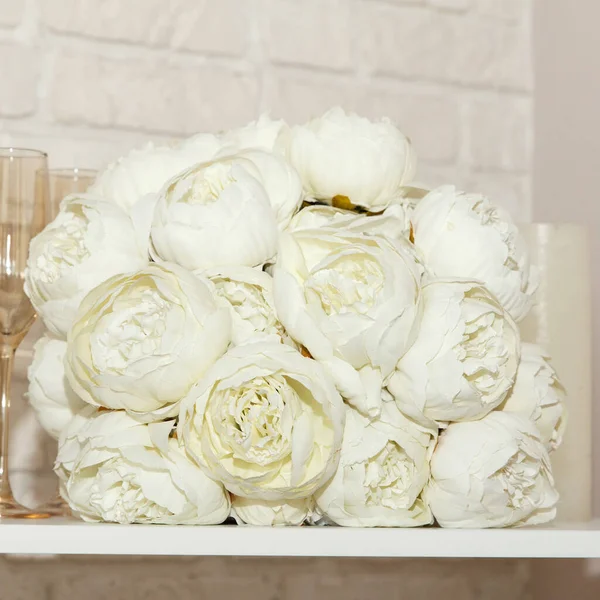結婚式の白い牡丹の花束 白いろうそくが棚に横たわっています 花嫁のための美しい結婚式セット 美しい背景 正方形 — ストック写真