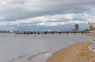Seascape, early summer mornings and people in the distance meet beautiful dawn on pier