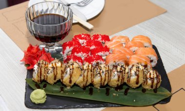 Somon, tobiko ve tempura içeren suşi çeşitleri, tahta tabakta, beyaz ahşap masada, konsept. 