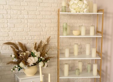 Düğün odasının içinde. Rafta gelin çiçekleri, mumlar, bardaklar ve ayakkabılar var. Güzel arkaplan.