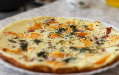 Portakal domatesli, dolmalık biberli, otlu ve jambonlu lezzetli bir omlet. Tabak beyaz bir tabakta servis edilir, parçalara ayrılır, kahvaltı için.