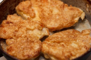 Tavada kızartılmış tavuk pirzolası. Kıtır kıtır bir doku ve iştah açıcı bir görünüş. Gıda ile ilgili temalar ve mutfak sunumları için ideal