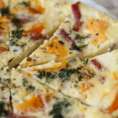 Portakal domatesli, dolmalık biberli, otlu ve jambonlu lezzetli bir omlet. Tabak beyaz bir tabakta servis edilir, parçalara ayrılır, kahvaltı için.