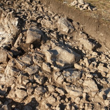 Açık bilimsel çalışma arkeolojik kazı alanı detaylı toprak katmanları ve tebeşirli yüzey, gün ışığı fotoğrafı, doğal arazi, antik çukur kavramı
