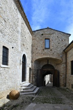 İtalya 'nın Puglia eyaletindeki bir ortaçağ köyü olan Pietramontecorvino' nun eski evleri arasında dar bir sokak..