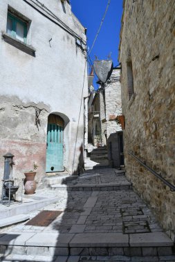 İtalya 'nın Puglia eyaletindeki bir ortaçağ köyü olan Pietramontecorvino' nun eski evleri arasında dar bir sokak..