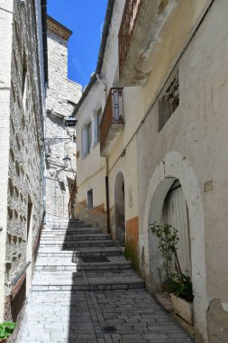 İtalya 'nın Puglia eyaletindeki bir ortaçağ köyü olan Pietramontecorvino' nun eski evleri arasında dar bir sokak..