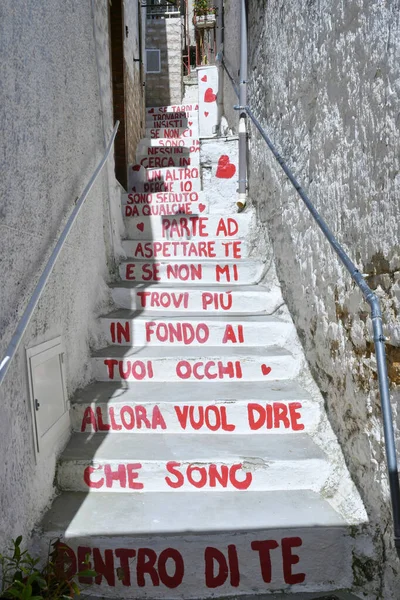 İtalya 'nın Puglia eyaletindeki bir ortaçağ köyü olan Pietramontecorvino' nun eski evleri arasında dar bir sokak..