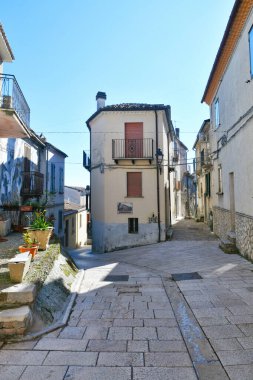 İtalya 'nın Molise eyaletindeki tarihi bir kasaba olan Civitacampomarano' nun eski evleri arasında dar bir sokak..