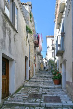 İtalya 'nın Molise eyaletindeki tarihi bir kasaba olan Civitacampomarano' nun eski evleri arasında dar bir sokak..