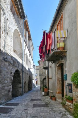 İtalya 'nın Molise eyaletindeki tarihi bir kasaba olan Civitacampomarano' nun eski evleri arasında dar bir sokak..