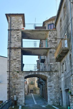 İtalya 'nın Molise eyaletindeki tarihi bir kasaba olan Civitacampomarano' nun eski evleri arasında dar bir sokak..