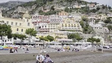 İtalya 'nın Amalfi kıyısındaki bir kasabanın plajındaki turistler.