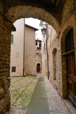 İtalya 'nın Perugia eyaletindeki bir ortaçağ kasabası olan Spoleto' nun antik binaları arasında dar bir sokak.