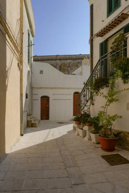 İtalya 'nın Matera ilindeki bir ortaçağ köyü olan Montescaglioso' nun eski evleri arasında bir yol..