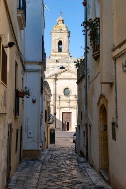 İtalya 'nın Matera ilindeki bir ortaçağ köyü olan Montescaglioso' nun eski evleri arasında bir yol..