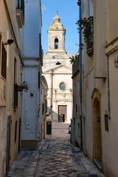 İtalya 'nın Matera ilindeki bir ortaçağ köyü olan Montescaglioso' nun eski evleri arasında bir yol..