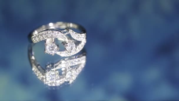 ダークブルーの背景にダイヤモンドリング 結婚指輪 エンゲージリング — ストック動画