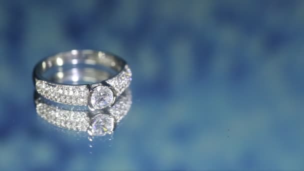 ダークブルーの背景にダイヤモンドリング 結婚指輪 エンゲージリング — ストック動画