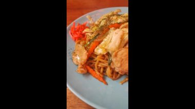 Kızarmış yakisoba şehriyesini vejetaryen usulü sebzeyle karıştırın.