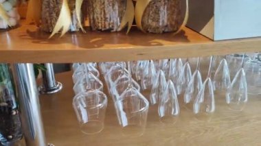Bar ve alkol kavramı. Süslü bir restoranda barın üstündeki askıda farklı tipte şeffaf bardaklar var. Boş şarap kadehleri oteldeki bir rafta baş aşağı asılı duruyor. Doli.
