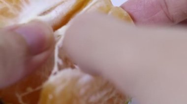 Birisi yemek için portakal soyuyormuş.