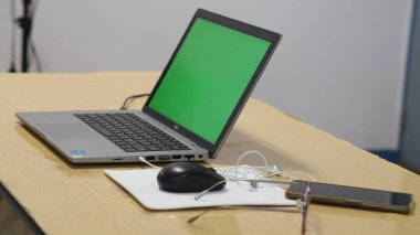 bilgisayar klavyesi, not defteri, gözlük, bilgisayar faresi ve cep telefonu ofis masasında.