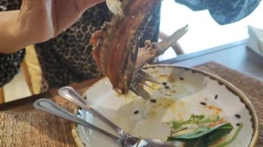 Çin restoranında servis edilen kızarmış sarımsak ve baharatlı Tayland biberiyle kaplanmış balık buğulama üzerine kızarmış balık.