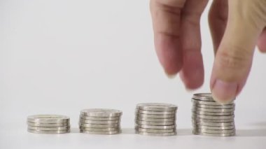 Erkeklerin elleri büyüyen gümüş para yığınlarını istifliyor Para kavramı ve tasarruf