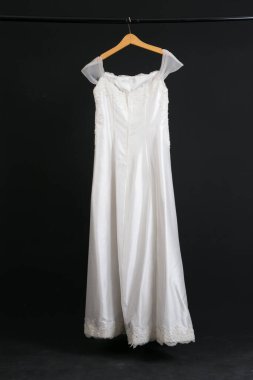 Siyah arka planda asılı gelinlik