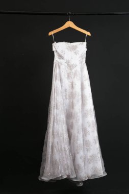 Siyah arka planda asılı gelinlik