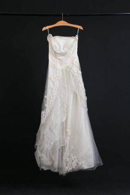 Siyah arka planda asılı gelinlik