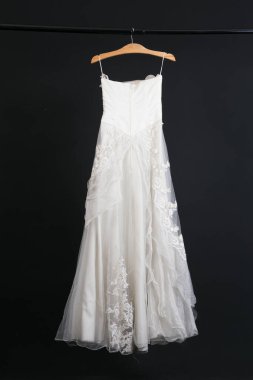 Siyah arka planda asılı gelinlik