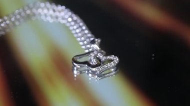 Çift kalp kolyesi, gümüş rengi, açık altın arka planda. kalp gümüş zincir üzerinde