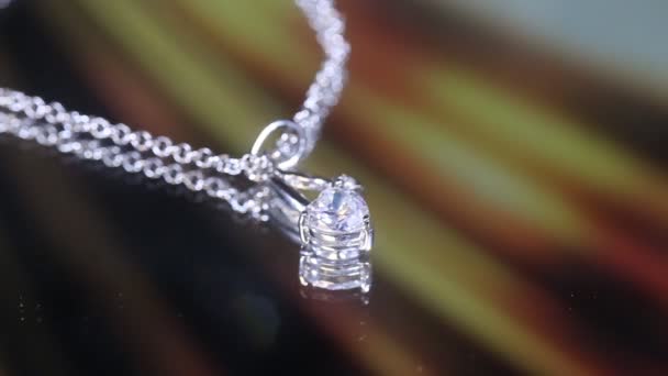 매크로 사진으로 배경에 화이트 골드에 다이아몬드가있는 모양의 펜던트 — 비디오